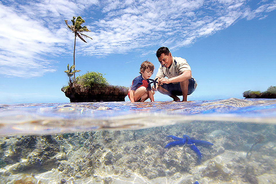 Private-Island-7-Fiji-Luxury-Travel A resident biologist seen spending time educating a child. Jean-Michel Cousteau Resort, Fiji, a pioneer in Eco-Luxury, champions sustainability, ecological preservation, and community education.